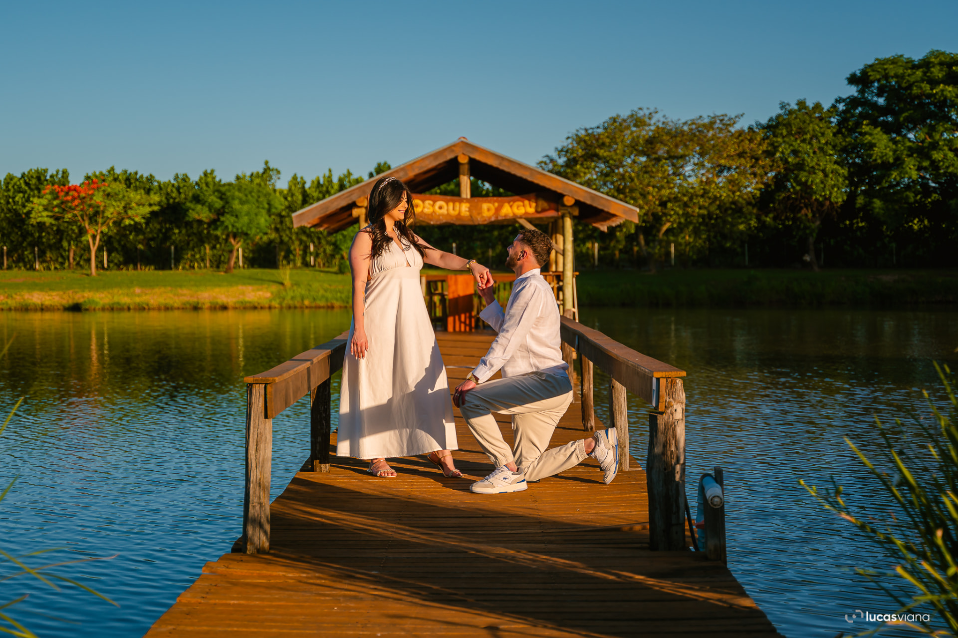 Casal no píer de madeira sobre o lago da fazenda